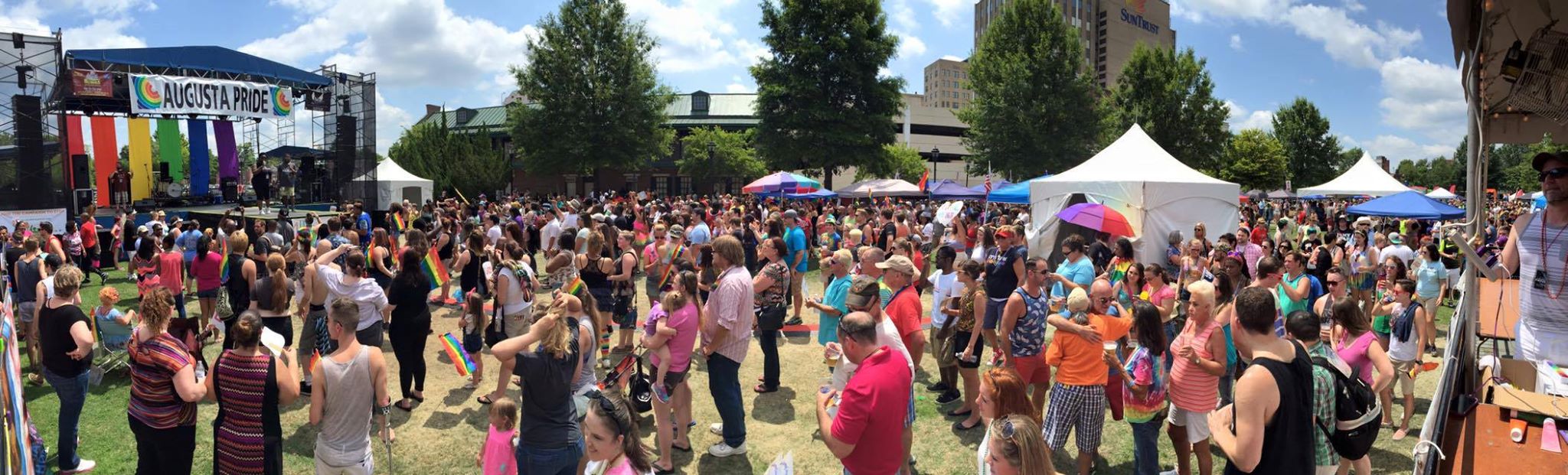 Background photo of Augusta Pride Festival with stage and attendees